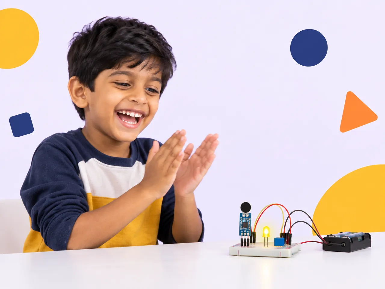 A boy claps and laughs as his sound-activated light switches on